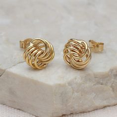 PRODUCT DESCRIPTION * These solid gold mini rose wire stud earrings feature strands of 9ct gold woven together to form a stunning rose-styled knot. Measuring 6mm, these earrings are perfect for everyday wear and make a thoughtful gift for her. These unique earrings put a twist on the classic love knot studs.  * Ideal for a golden anniversary or milestone birthdays such as a 21st, 30th, 40th, or 50th, they symbolise eternal love, making them the perfect gift for a girlfriend or wife. ONE YEAR WAR Love Knot Gold Earrings, Gold Butterfly Knot Earrings, Love Knot Earrings Studs, Rose Gold 14k Gold-filled Earrings Gift, Gold Knot Earrings, Golden Anniversary Gifts, Mens Bracelet Personalized, Milestone Birthday Gifts, Girls Personalized Gifts