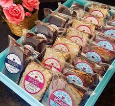 a blue tray filled with lots of different types of cakes and pastries on top of a table