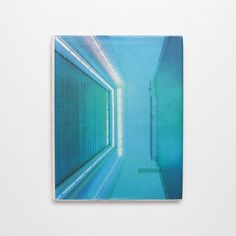 a book with an image of a swimming pool in the middle, on top of a white wall