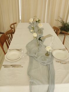 the table is set with flowers and place settings for two people to sit down at