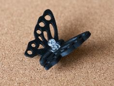 a black butterfly shaped object sitting on top of a table