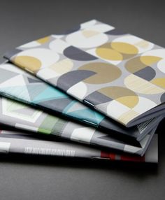 four folded napkins are stacked on top of each other, with different patterns and colors