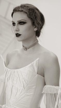 a woman in a white dress with black lipstick