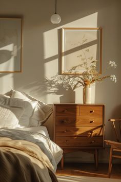 a bedroom scene with focus on the bed and dresser, which has a plant in it