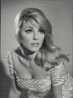 an old black and white photo of a woman with long blonde hair wearing a dress