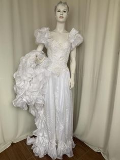 a mannequin wearing a white dress with large ruffles on it's shoulders