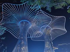 two tall metal sculptures with lights on them