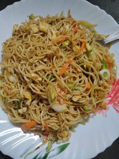 a white plate topped with noodles and vegetables