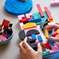 a child is playing with legos on the table in front of some other toys