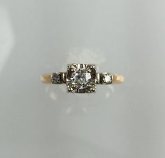 an antique diamond ring with three stones on the side and two diamonds in the middle