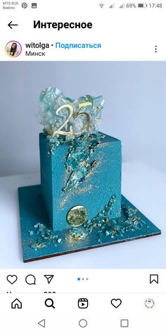 a blue cake with gold decorations on it