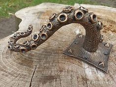 an old metal object sitting on top of a tree stump