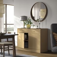 a living room with a chair, table and mirror on the wall next to it