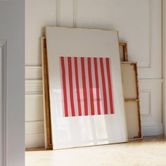 an image of a red and white striped art print on the wall next to a bookcase