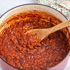 a pot filled with beans and a wooden spoon