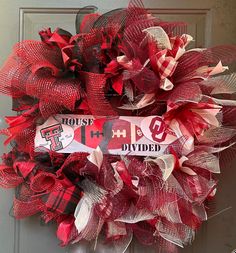 a red and white wreath with the word house divided written on it in front of a door