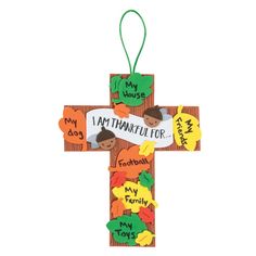 a wooden cross with the words i am thanksgiving written on it and an orange ribbon hanging from