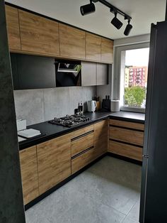 a kitchen with wooden cabinets and black counter tops in front of a large open window