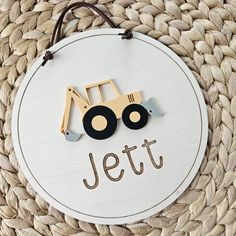 a wooden sign with a tractor on it that says jeltt next to a woven basket