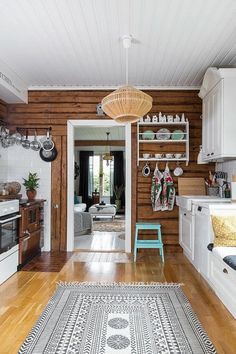 a kitchen with wood paneling and white cabinets is seen in this image from the doorway