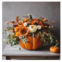 a pumpkin filled with flowers sitting on top of a table