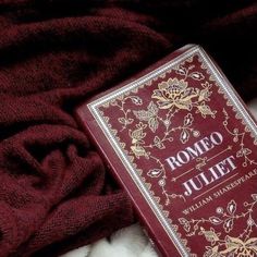 a red book sitting on top of a bed next to a pile of white fur