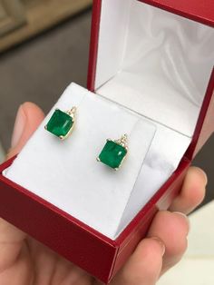 Elegance defined! These emerald and diamond earrings are fashioned in solid 14k yellow gold. These studs feature natural Asscher cut emeralds accented with natural white diamonds. The emeralds have a combined 2.81 total carat weight and a dark green hue that contrasts with the flashing fire of the diamonds. The brilliant round diamonds have a combined 11 points. Perfect for every day! Setting Style: Emerald & Diamond Studs Setting Weight: 2.0 grams Setting Material: 14K Yellow Gold Main Ston Elegant Green Diamond Earrings In 14k Gold, Formal Yellow Gold Diamond And Emerald Earrings, Emerald Yellow Gold Diamond Earrings Fine Jewelry, Emerald Yellow Gold Diamond Earrings, Green Emerald Cut Diamond Earrings For Anniversary, Emerald Cut Green Diamond Earrings For Anniversary, Yellow Gold Emerald Diamond Earrings, Yellow Gold Diamond Earrings With Emerald, Green Diamond Earrings For Anniversary