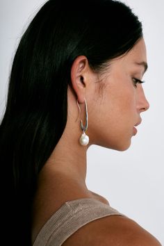 A surrealist inspired take on our crescent hoops, these sterling silver earrings have a dramatic shape and a dash of witty charm. Finished with a striking baroque pearl for an added touch of elegance. An essential design perfect on its own or paired with smaller hoops or studs. Sterling silver. 2 1/2" drop. Handmade in Vietnam. Handmade Box, Vintage Fabrics, Baroque Pearls, Pearl White, Crescent, Sterling Silver Earrings, Silver Earrings, Vietnam, Pearl Earrings