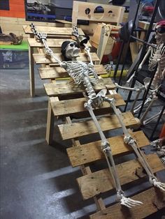 two skeletons are sitting on wooden pallets in a shop