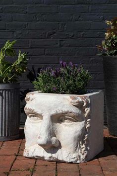 a white face planter sitting on top of a brick floor