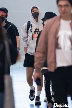 people wearing face masks walking through an airport