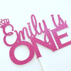 a pink cake topper that says,'bridal is one'with a crown on it