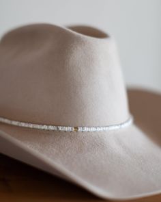 The perfect addition to any hat, our beaded hat bands feature a variety of semi-precious gemstones with leather ties for an adjustable closure to fit any hat. Dimensions: 21" beaded length before leather ties Material: Various Stones/Beads, Leather Cording Hardware: Gold Plated Jump Rings and Crimp Beads Closure: Leather Ties - brown for all stone options except pyrite, which uses black Stone Options: African TurquoiseTurquoiseLabradoritePyriteWhite HowlitePicasso JasperAqua Terra Jasper Handmad Western Style Adjustable Beaded Jewelry, Adjustable Beaded Fedora Hat Band, Adjustable Bead Cap Hat Bands For Festival, Adjustable Hat Band With Bead Caps For Festival, Adjustable Artisan Hat Bands For Ranch, Adjustable Beaded Hat Bands For Rodeo, Adjustable Beaded White Hat Bands, Artisan Adjustable Hat As A Gift, Adjustable Beaded Hat Bands