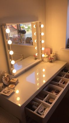 a vanity with drawers and lights on it