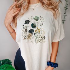 This Pressed Wildflowers T-shirt is a soft-washed, garment-dyed fabric that brings extra coziness to your wardrobe while the relaxed fit makes it an excellent daily choice. The double-needle stitching throughout the tee makes it highly durable while the lack of side-seams helps the shirt retain its tubular shape. .: 100% ring-spun cotton .: Medium fabric (6.1 oz/yd² (206.8 g/m .: Relaxed fit .: Sewn-in twill label Oversized Floral Print T-shirt For Spring, Summer Cotton Floral Print T-shirt, Casual Watercolor Print T-shirt With Relaxed Fit, Botanical Plants Print Relaxed Fit T-shirt, Everyday Floral Print Short Sleeve Top, Green Bohemian Crew Neck T-shirt, Cotton Botanical T-shirt For Spring, Spring Relaxed Fit T-shirt With Watercolor Print, Spring Organic Cotton Relaxed Fit T-shirt