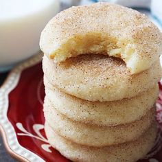 a stack of sugary donuts on a red and white plate