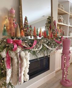 the fireplace is decorated for christmas with pink decorations on top and green garland around it