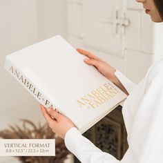 a woman is holding a book in her hands