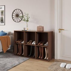 a bedroom with white walls and wooden flooring is furnished with an open shelving unit