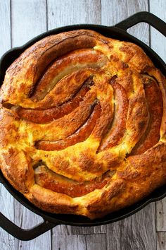 a skillet filled with bread on top of a wooden table