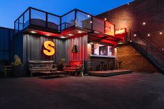 the outside of a restaurant with red lights and stairs leading up to it's entrance