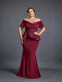 a woman in a red gown posing for the camera with her hands on her hips