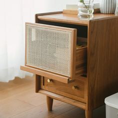 a wooden side table with drawers and a potted plant sitting on top of it