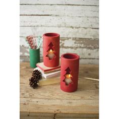 two red candles sitting on top of books