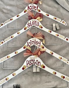 four personalized wooden hangers with bows on them