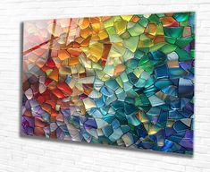 an abstract painting on a brick wall with multicolored glass tiles in the background