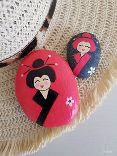 two painted rocks sitting on top of a straw hat