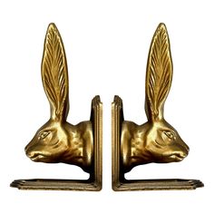 two golden bookends with an animal head on each one's face and wings