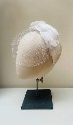 "FABRIC This Women's fascinator headband is carefully hand made. The headband has been covered in luxury white mulberry silk and each feather has been attached within the seams of the fabric headband for a flawless finish. The head crown is light, soft and super comfortable and boasts a quality finish. it also features a beautiful handmade blusher veil with comb fixture. FIT and SIZE A flexible base band to fit all head sizes.  PACKAGING Each headband is wrapped in pretty acid free tissue paper, sealed with an Evierosemade brand sticker and shipped in an eco-friendly cardboard gift box to protect while in transit. If you are purchasing as a gift, please select \"This order is a gift\" (the item price will not be included in the gift box). If you would also like to add a personalised messag White Costume Hat With Round Crown For Parties, White Adjustable Costume Hat With Pinched Crown, Elegant White Veil For Ceremony, Elegant White Ceremony Veil, Elegant White Evening Veil, White Fascinator With Matching Headband For Party, Adjustable White Headpiece For Ceremony, Adjustable White Headpiece For Ceremonies, Elegant Wedding Headband Veil