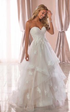 a woman in a white wedding dress posing for the camera